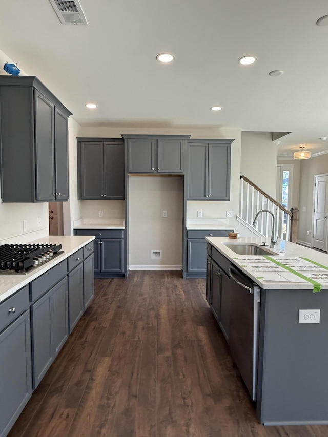 kitchen with visible vents, dark wood-type flooring, gray cabinets, a sink, and appliances with stainless steel finishes