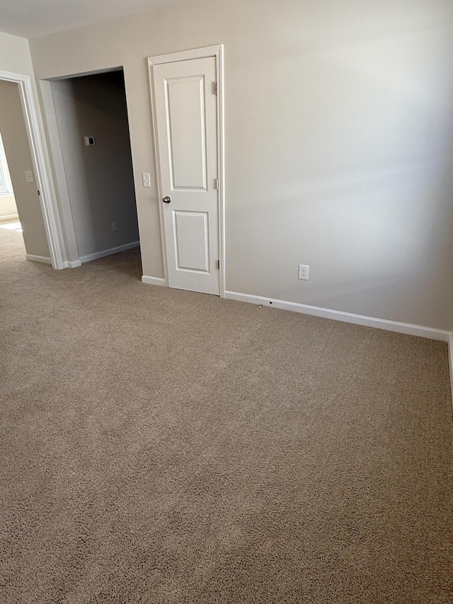 carpeted spare room featuring baseboards