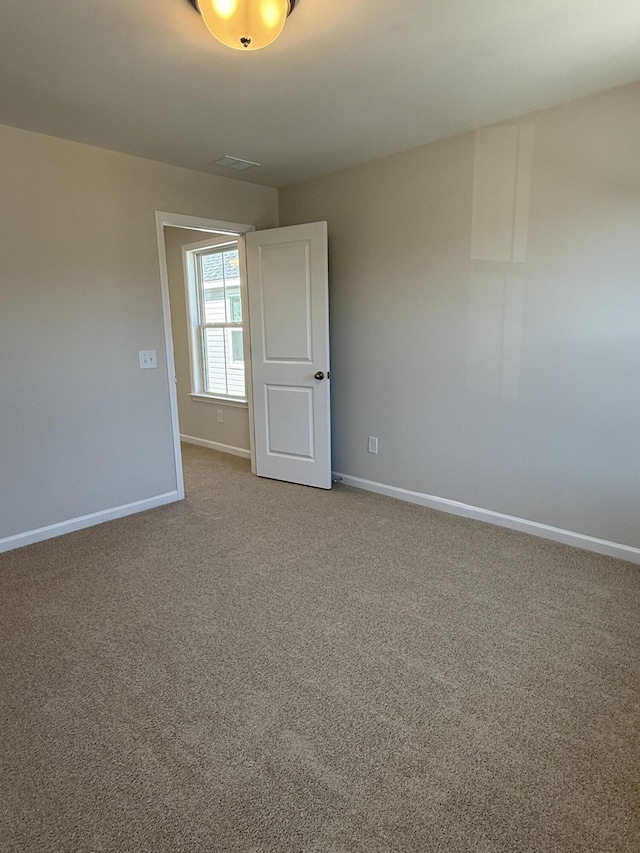 empty room featuring baseboards and carpet flooring