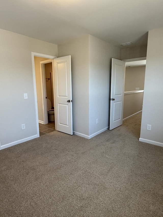 unfurnished bedroom featuring visible vents, carpet floors, and baseboards