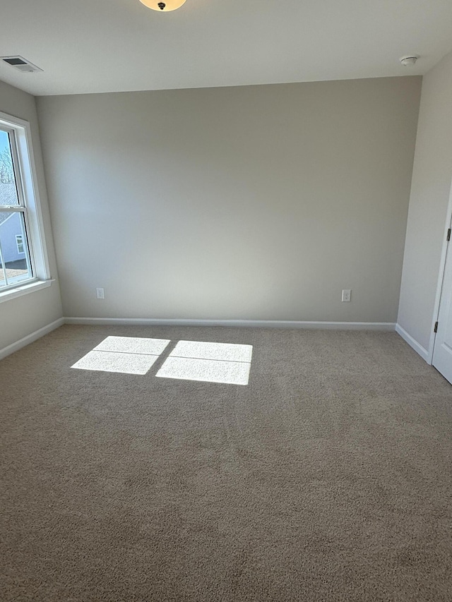 unfurnished room featuring visible vents, baseboards, and carpet floors