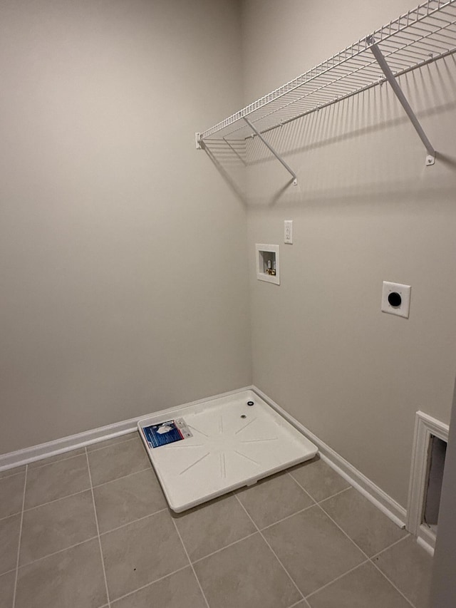 laundry area featuring baseboards, washer hookup, laundry area, and tile patterned flooring