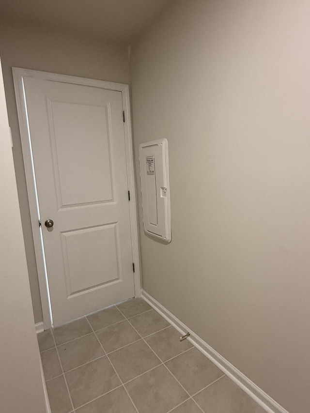 interior space featuring tile patterned flooring, electric panel, and baseboards