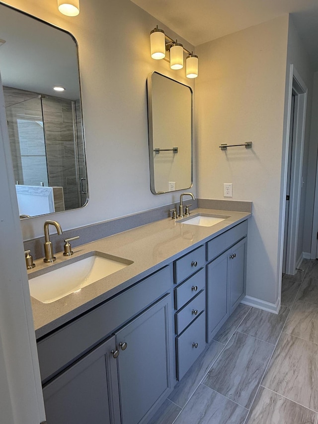 full bathroom with a sink, baseboards, a shower stall, and double vanity