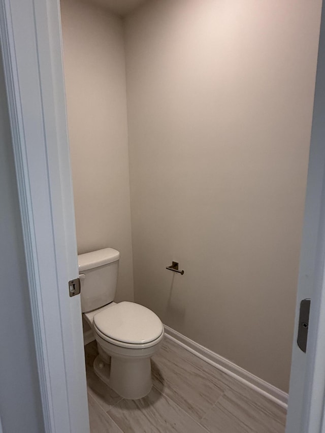 bathroom with toilet and baseboards