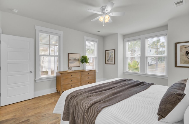 bedroom with multiple windows, light hardwood / wood-style flooring, and ceiling fan