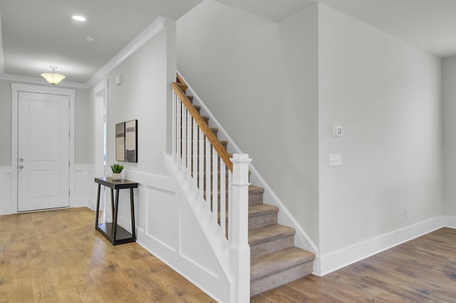 entrance foyer featuring wood-type flooring and ornamental molding