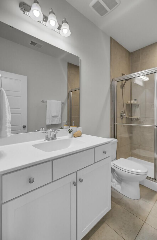 bathroom with an enclosed shower, tile patterned flooring, vanity, and toilet