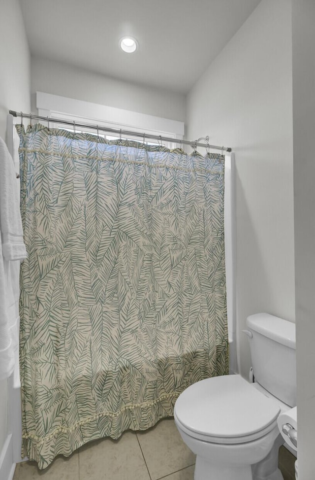 bathroom featuring tile patterned floors, curtained shower, and toilet