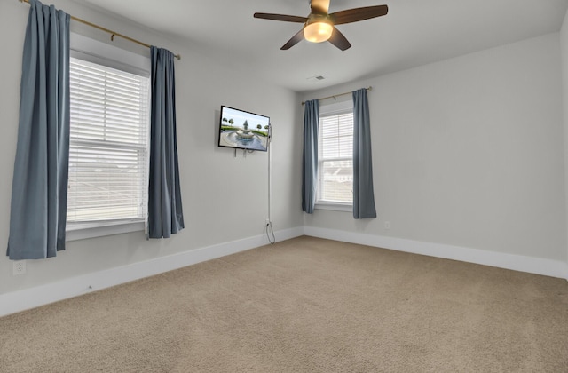 carpeted spare room featuring ceiling fan