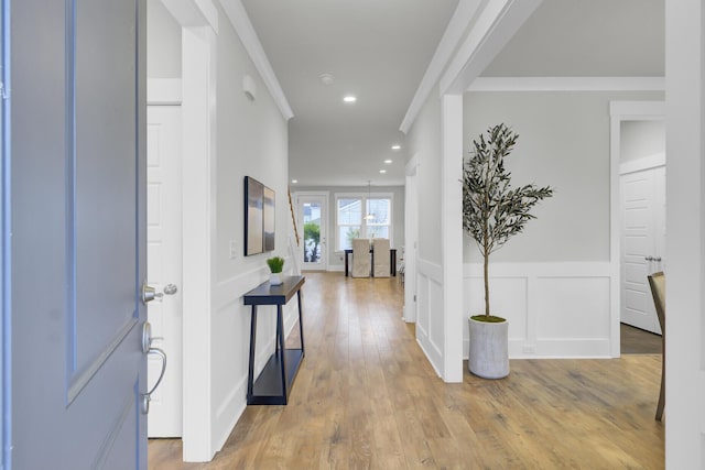 entrance foyer featuring light wood-type flooring and crown molding