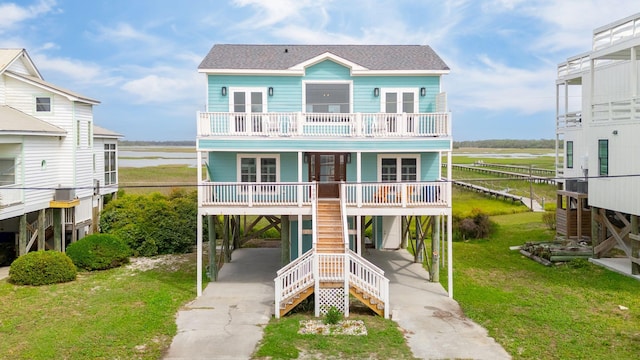 1568 E Ashley Ave, Folly Beach, SC 29439 - view of front of home featuring a carport, a porch, stairway, a balcony, and a front lawn