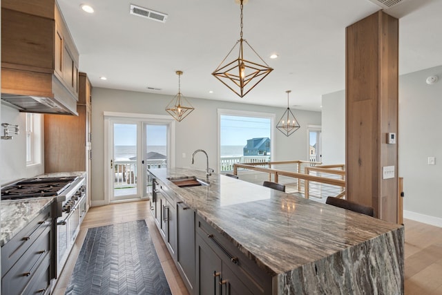 1568 E Ashley Ave, Folly Beach, SC 29439 - kitchen featuring a sink, stainless steel stove, plenty of natural light, recessed lighting, and a large island
