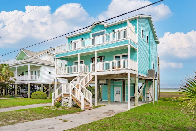 1568 E Ashley Ave, Folly Beach, SC 29439 - beach home featuring covered porch, a carport, a balcony, and a front yard