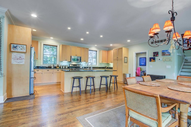 dining area with light hardwood / wood-style flooring, sink, and ornamental molding