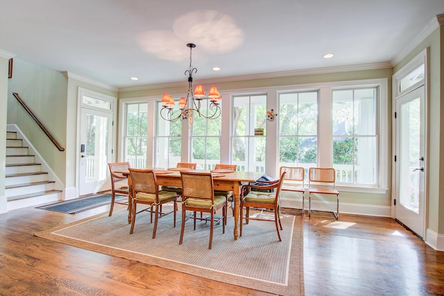 dining room featuring wood-type flooring, a notable chandelier, and ornamental molding