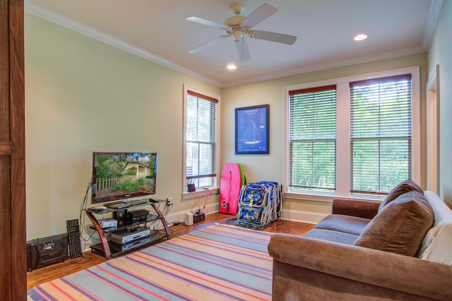 living room with hardwood / wood-style floors, ceiling fan, crown molding, and a wealth of natural light