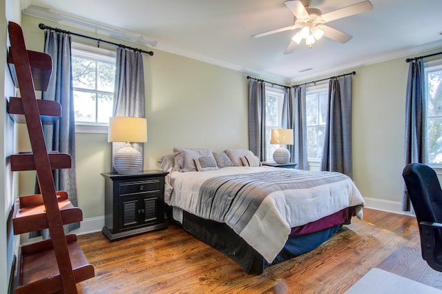 bedroom featuring ornamental molding, wood-type flooring, and ceiling fan