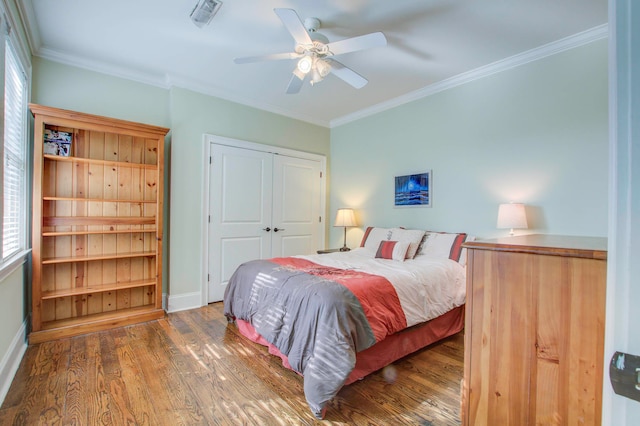 bedroom with crown molding, a closet, wood-type flooring, and ceiling fan