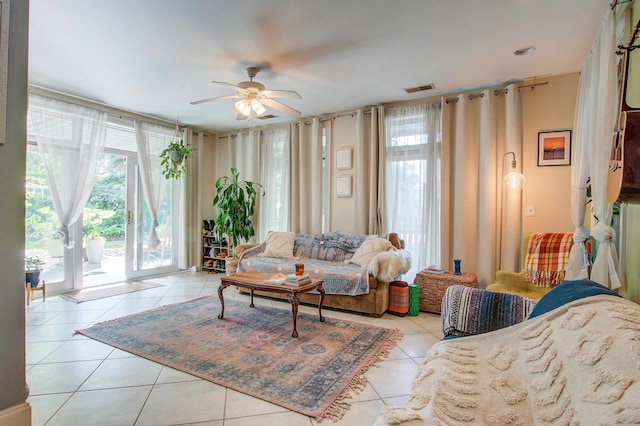 tiled living room with a wealth of natural light and ceiling fan