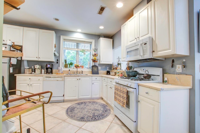 kitchen with white cabinetry, sink, white appliances, and light tile floors