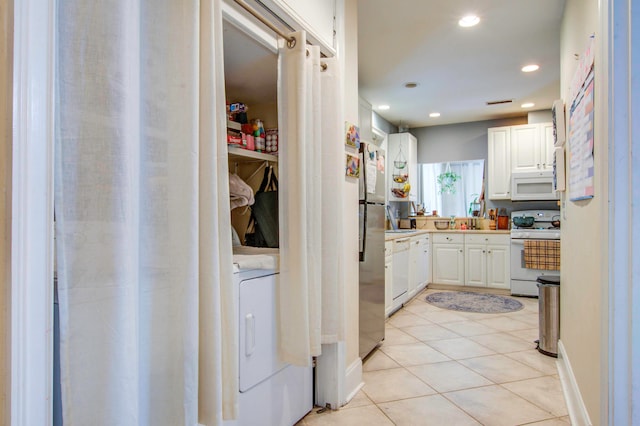 kitchen featuring white cabinets, white appliances, and light tile flooring