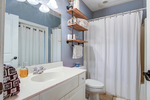 bathroom with toilet, tile floors, and vanity