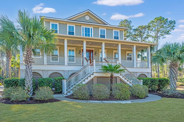 beach home with stairs, covered porch, and a front yard