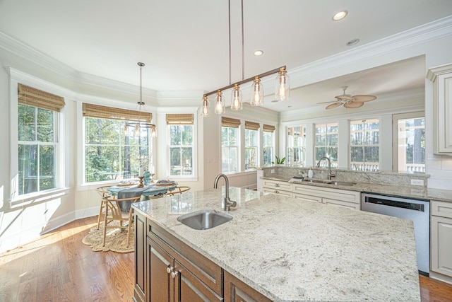 kitchen featuring dishwasher, ornamental molding, wood finished floors, and a sink