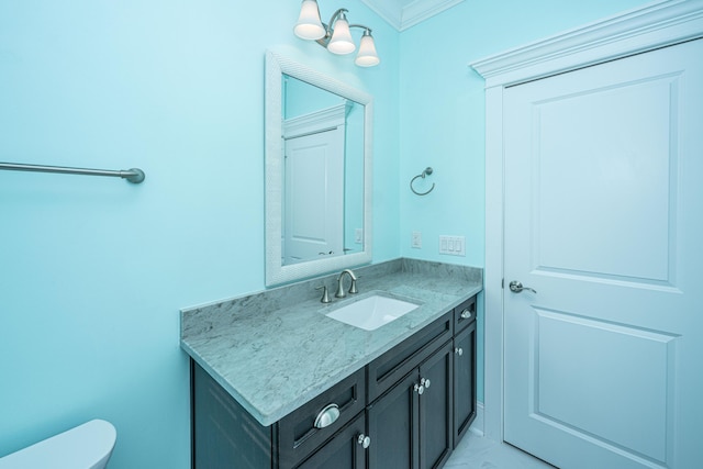 bathroom with toilet, ornamental molding, and vanity