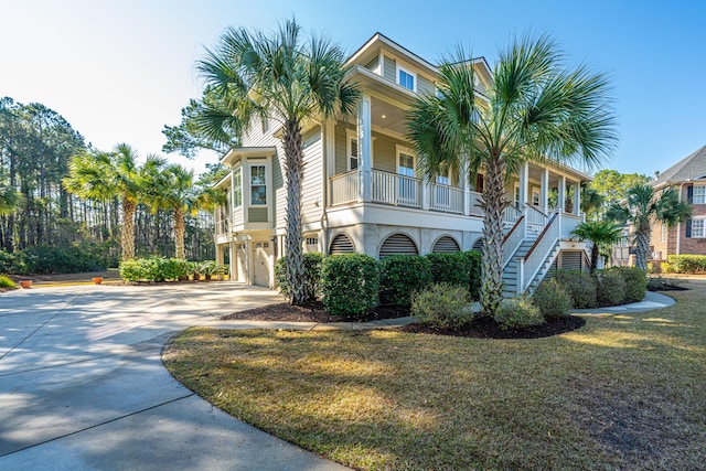 view of front of home with a front yard, driveway, stucco siding, stairs, and a garage