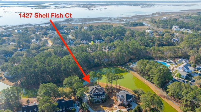 birds eye view of property featuring a wooded view and a water view