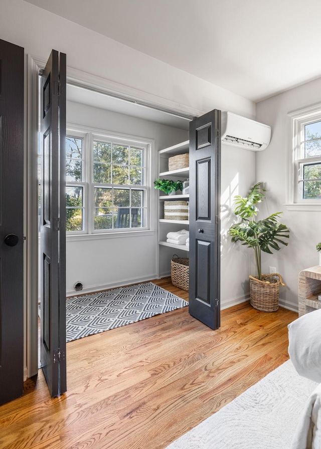 mudroom featuring a wall mounted AC and hardwood / wood-style floors