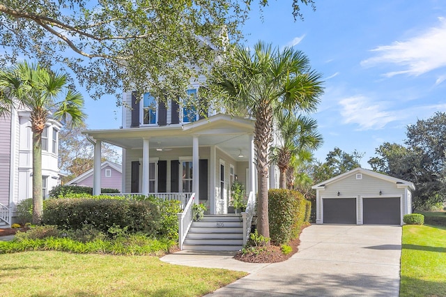 view of front of home featuring a garage, a front yard, covered porch, and an outbuilding