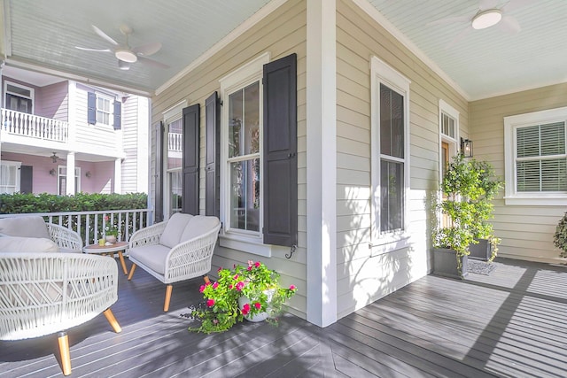 wooden deck featuring covered porch and ceiling fan