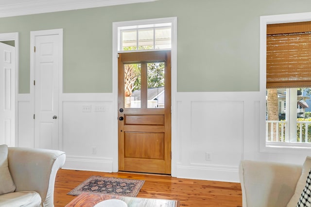 entrance foyer with hardwood / wood-style floors and crown molding