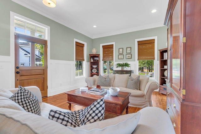 living room with light wood-type flooring and crown molding