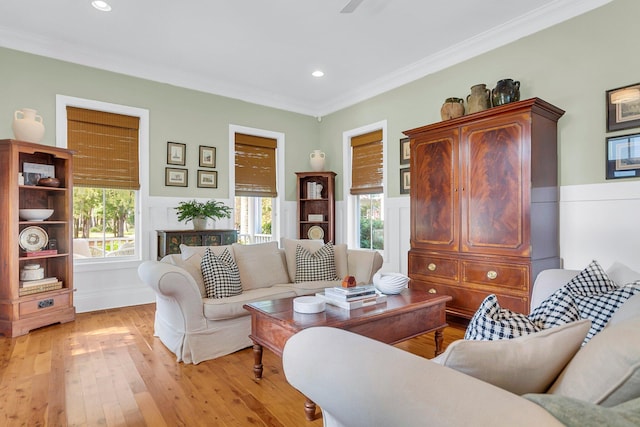 living room with light hardwood / wood-style floors, a healthy amount of sunlight, and crown molding