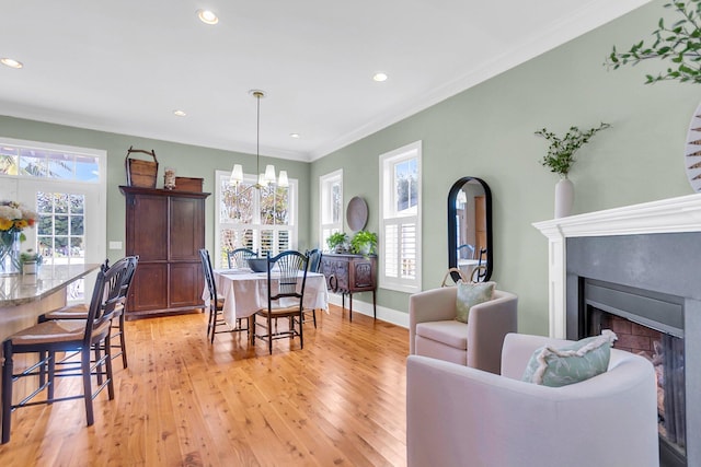 living room with light wood-type flooring, an inviting chandelier, and ornamental molding