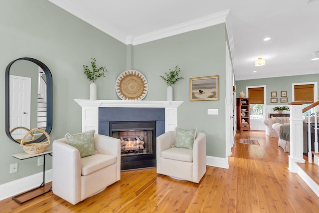 living area featuring hardwood / wood-style floors and crown molding