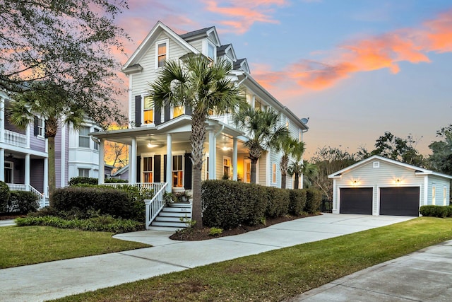 view of front of home with an outbuilding, a garage, a yard, and covered porch