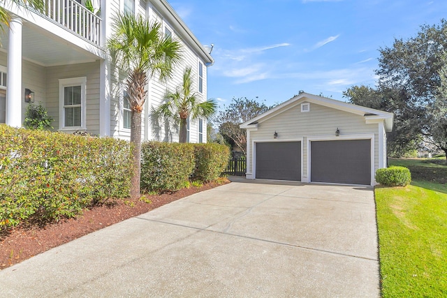 view of side of home featuring an outbuilding, a garage, and a balcony