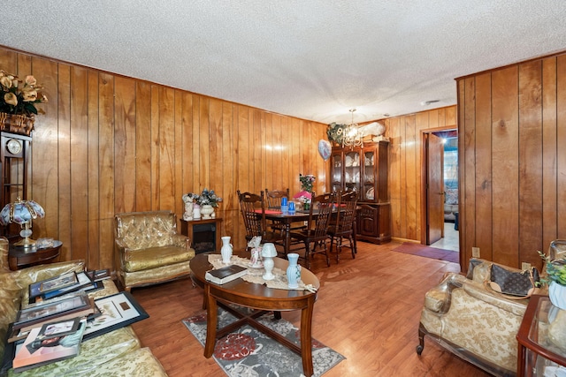 12 Grove St, Charleston, SC 29403 - living room featuring a textured ceiling, wooden walls, wood finished floors, and a chandelier