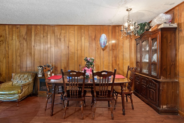 12 Grove St, Charleston, SC 29403 - dining space with a chandelier, wood walls, a textured ceiling, and wood finished floors