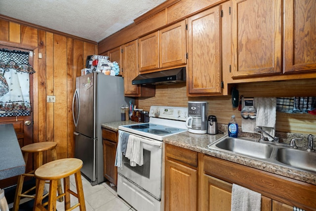 12 Grove St, Charleston, SC 29403 - kitchen with under cabinet range hood, white electric stove, a sink, brown cabinets, and a textured ceiling