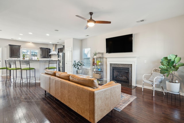 living room with ceiling fan and dark wood-type flooring