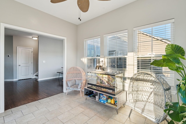 living area featuring ceiling fan, light tile patterned flooring, and a healthy amount of sunlight