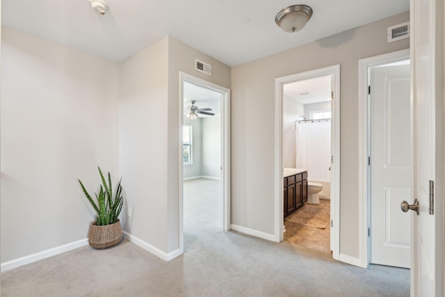 hallway featuring light colored carpet