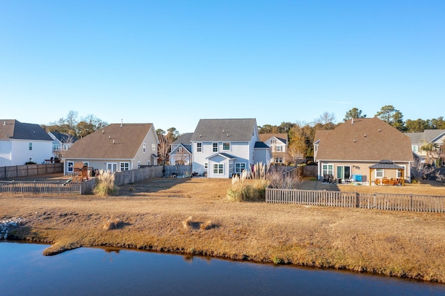 rear view of house featuring a gazebo and a water view