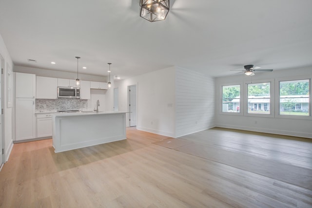 2135 Clayton St, Charleston, SC 29414 - kitchen with stainless steel microwave, open floor plan, white cabinetry, ceiling fan, and recessed lighting